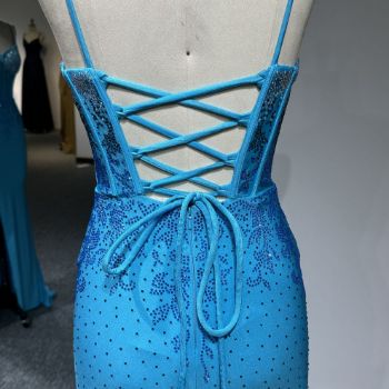 The criss-crossing back straps elegantly accentuate the exposed back, enhancing the gown’s sensual allure.​
